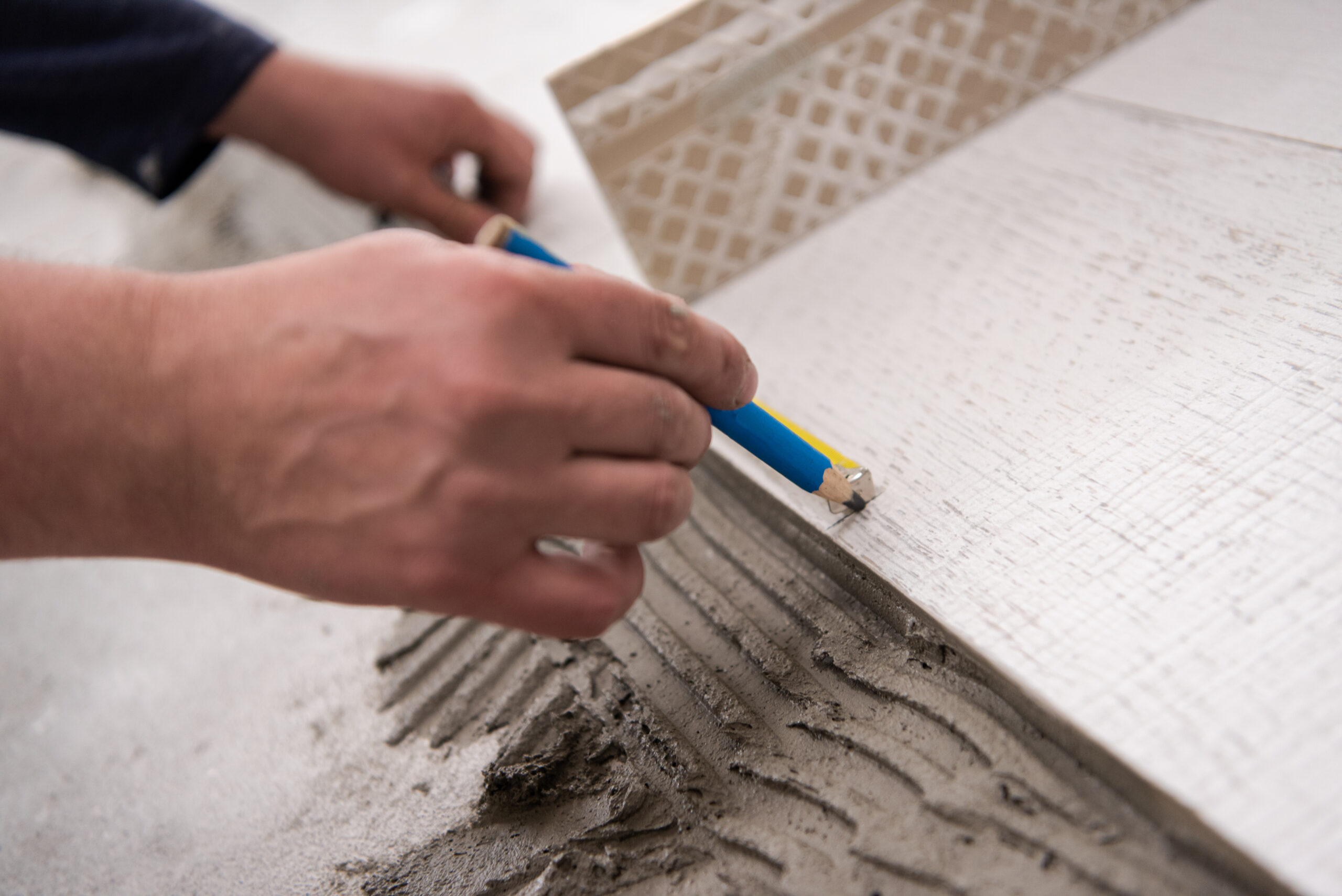 skilled worker installing the ceramic wood effect tiles on the floor Worker making laminate flooring on the construction site of the new apartment